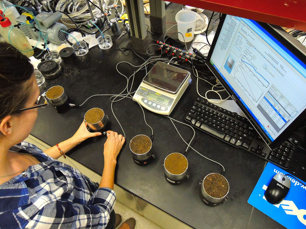 Researcher in a lab with soil testing equipment.